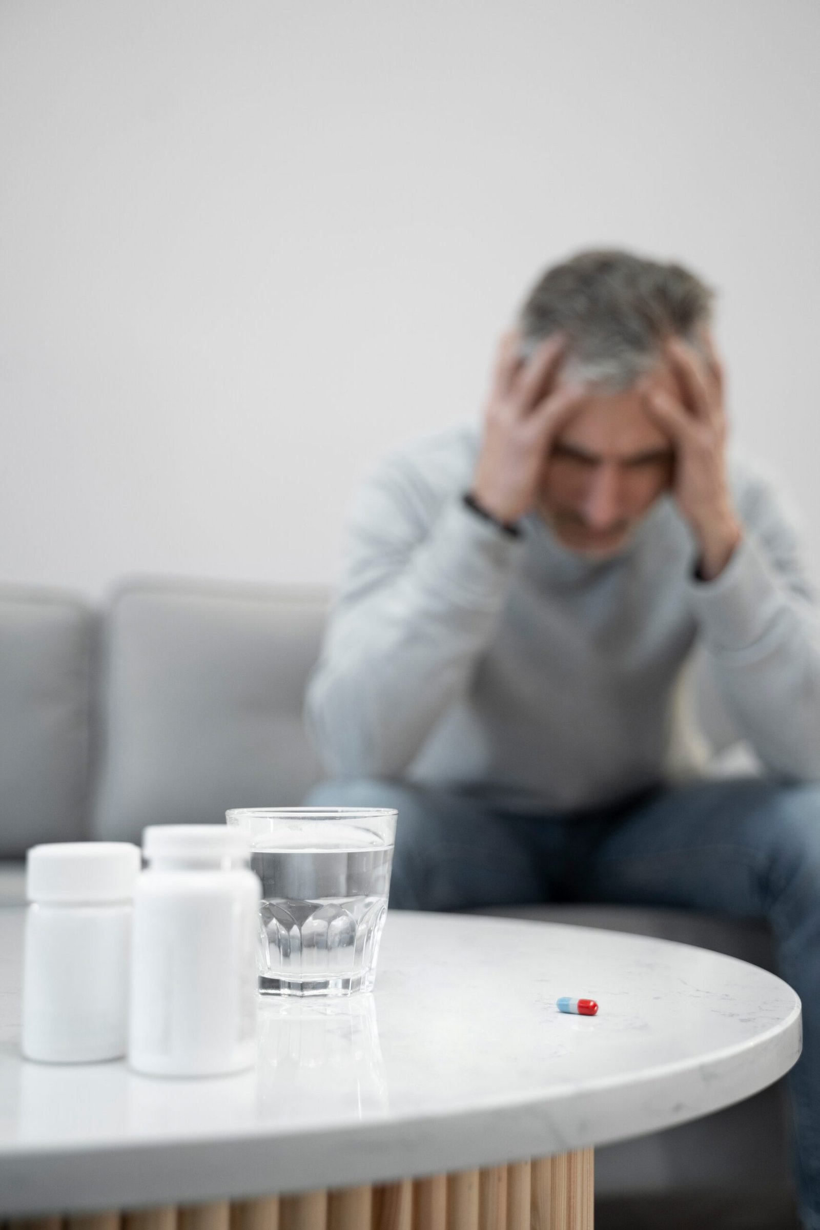 Uomo stressato seduto, con la testa tra le mani